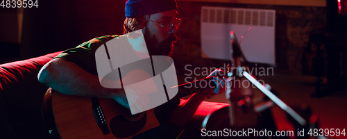 Image of Close-up of musician performing in neon light. Concept of advertising, hobby, music, festival, entertainment.