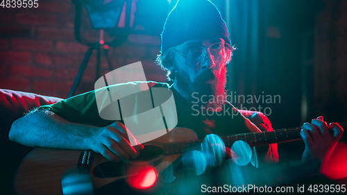 Image of Close-up of musician performing in neon light. Concept of advertising, hobby, music, festival, entertainment.