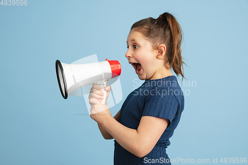 Image of Pretty caucasian girl portrait isolated on blue studio background with copyspace