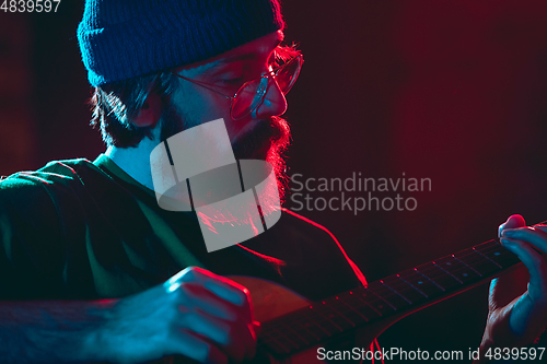 Image of Close-up of musician performing in neon light. Concept of advertising, hobby, music, festival, entertainment.