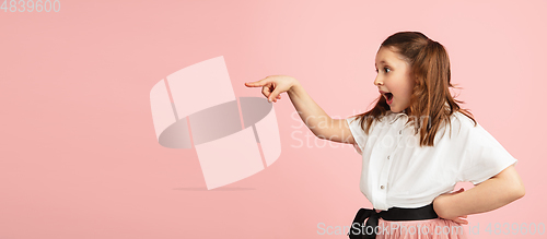 Image of Pretty caucasian girl portrait isolated on pink studio background with copyspace