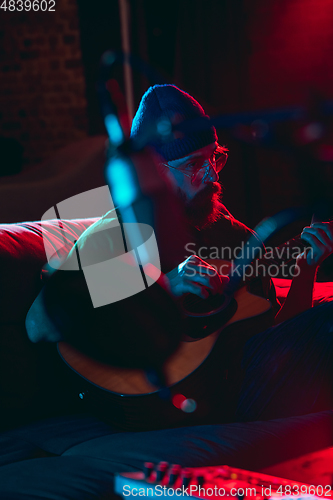 Image of Close-up of musician performing in neon light. Concept of advertising, hobby, music, festival, entertainment.