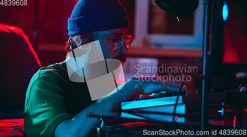 Image of Close-up of musician performing in neon light. Concept of advertising, hobby, music, festival, entertainment.