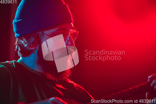 Image of Close-up of musician performing in neon light. Concept of advertising, hobby, music, festival, entertainment.