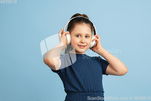 Image of Pretty caucasian girl portrait isolated on blue studio background with copyspace