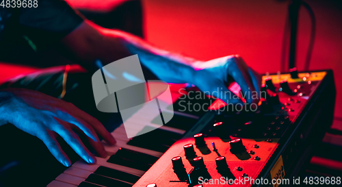 Image of Close-up of musician performing in neon light. Concept of advertising, hobby, music, festival, entertainment.