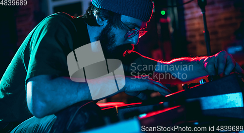 Image of Close-up of musician performing in neon light. Concept of advertising, hobby, music, festival, entertainment.