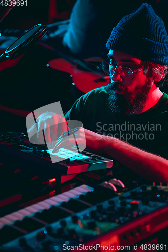 Image of Close-up of musician performing in neon light. Concept of advertising, hobby, music, festival, entertainment.