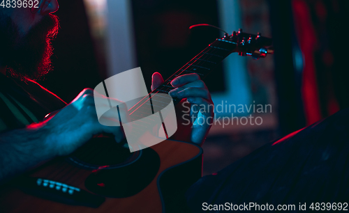 Image of Close-up of musician performing in neon light. Concept of advertising, hobby, music, festival, entertainment.