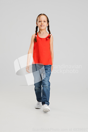 Image of Happy kid, girl isolated on white studio background. Looks happy, cheerful, sincere. Copyspace. Childhood, education, emotions concept