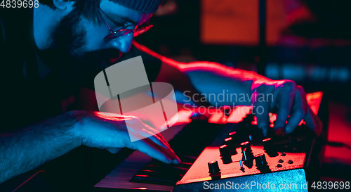 Image of Close-up of musician performing in neon light. Concept of advertising, hobby, music, festival, entertainment.