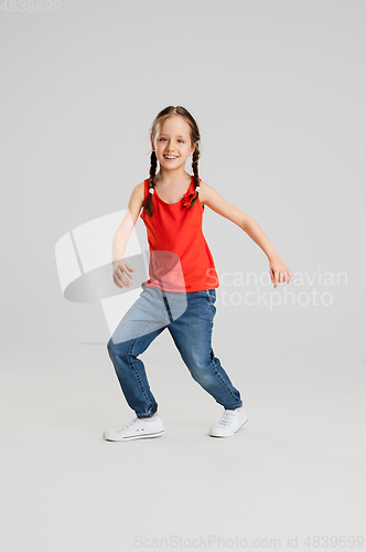 Image of Happy kid, girl isolated on white studio background. Looks happy, cheerful, sincere. Copyspace. Childhood, education, emotions concept