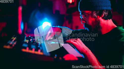 Image of Close-up of musician performing in neon light. Concept of advertising, hobby, music, festival, entertainment.