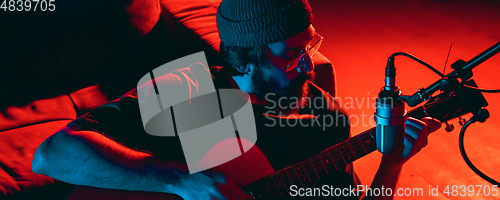 Image of Close-up of musician performing in neon light. Concept of advertising, hobby, music, festival, entertainment.