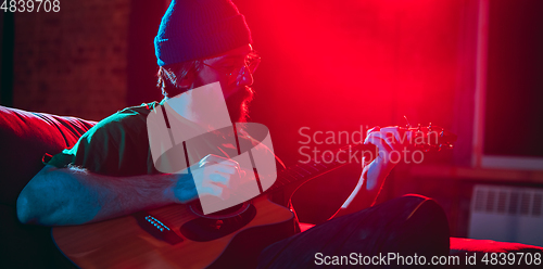 Image of Close-up of musician performing in neon light. Concept of advertising, hobby, music, festival, entertainment.