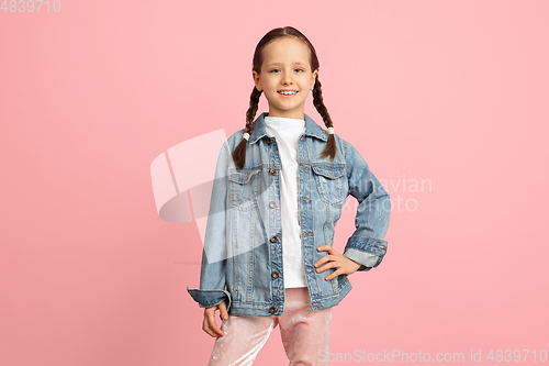 Image of Happy kid, girl isolated on pink studio background. Looks happy, cheerful, sincere. Copyspace. Childhood, education, emotions concept