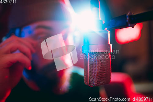 Image of Close-up of musician performing in neon light. Concept of advertising, hobby, music, festival, entertainment.