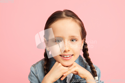 Image of Happy kid, girl isolated on pink studio background. Looks happy, cheerful, sincere. Copyspace. Childhood, education, emotions concept