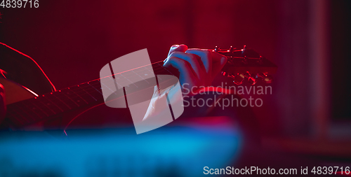 Image of Close-up of musician performing in neon light. Concept of advertising, hobby, music, festival, entertainment.