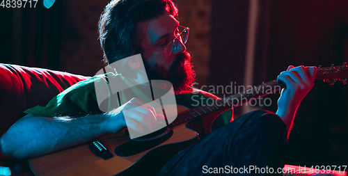 Image of Close-up of musician performing in neon light. Concept of advertising, hobby, music, festival, entertainment.