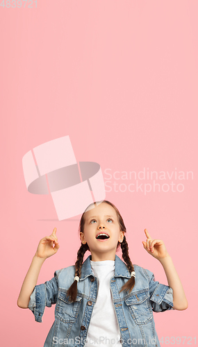 Image of Happy kid, girl isolated on pink studio background. Looks happy, cheerful, sincere. Copyspace. Childhood, education, emotions concept