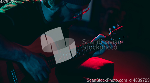 Image of Close-up of musician performing in neon light. Concept of advertising, hobby, music, festival, entertainment.