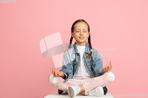 Image of Happy kid, girl isolated on pink studio background. Looks happy, cheerful, sincere. Copyspace. Childhood, education, emotions concept