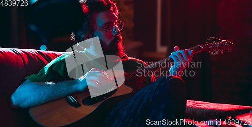 Image of Close-up of musician performing in neon light. Concept of advertising, hobby, music, festival, entertainment.