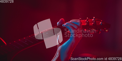 Image of Close-up of musician performing in neon light. Concept of advertising, hobby, music, festival, entertainment.