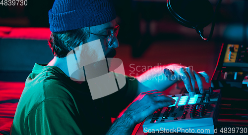 Image of Close-up of musician performing in neon light. Concept of advertising, hobby, music, festival, entertainment.