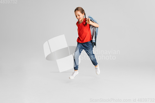 Image of Happy kid, girl isolated on white studio background. Looks happy, cheerful, sincere. Copyspace. Childhood, education, emotions concept