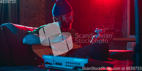 Image of Close-up of musician performing in neon light. Concept of advertising, hobby, music, festival, entertainment.