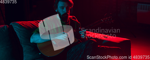 Image of Close-up of musician performing in neon light. Concept of advertising, hobby, music, festival, entertainment.