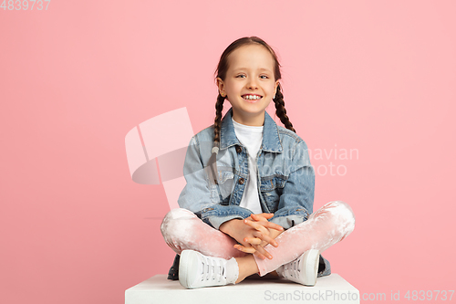 Image of Happy kid, girl isolated on pink studio background. Looks happy, cheerful, sincere. Copyspace. Childhood, education, emotions concept