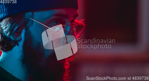 Image of Close-up of musician performing in neon light. Concept of advertising, hobby, music, festival, entertainment.