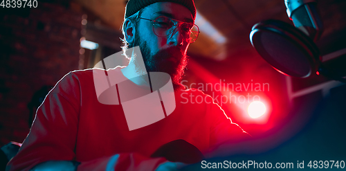 Image of Close-up of musician performing in neon light. Concept of advertising, hobby, music, festival, entertainment.