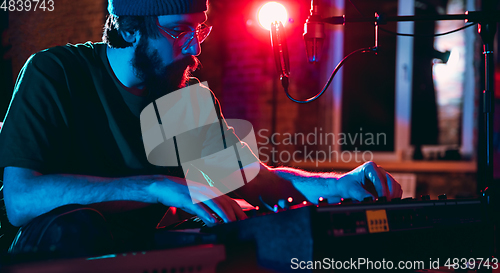 Image of Close-up of musician performing in neon light. Concept of advertising, hobby, music, festival, entertainment.