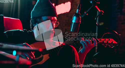 Image of Close-up of musician performing in neon light. Concept of advertising, hobby, music, festival, entertainment.