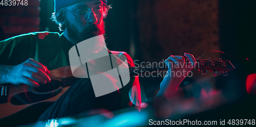 Image of Close-up of musician performing in neon light. Concept of advertising, hobby, music, festival, entertainment.