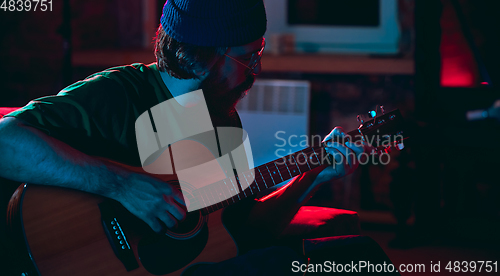 Image of Close-up of musician performing in neon light. Concept of advertising, hobby, music, festival, entertainment.