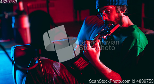 Image of Close-up of musician performing in neon light. Concept of advertising, hobby, music, festival, entertainment.