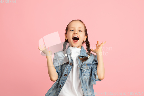 Image of Happy kid, girl isolated on pink studio background. Looks happy, cheerful, sincere. Copyspace. Childhood, education, emotions concept