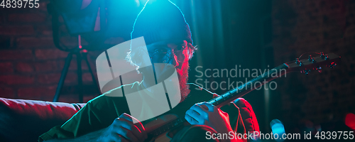 Image of Close-up of musician performing in neon light. Concept of advertising, hobby, music, festival, entertainment.