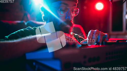 Image of Close-up of musician performing in neon light. Concept of advertising, hobby, music, festival, entertainment.