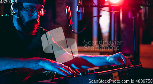 Image of Close-up of musician performing in neon light. Concept of advertising, hobby, music, festival, entertainment.