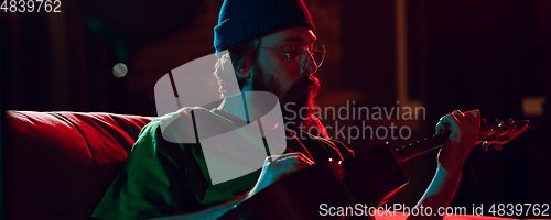 Image of Close-up of musician performing in neon light. Concept of advertising, hobby, music, festival, entertainment.