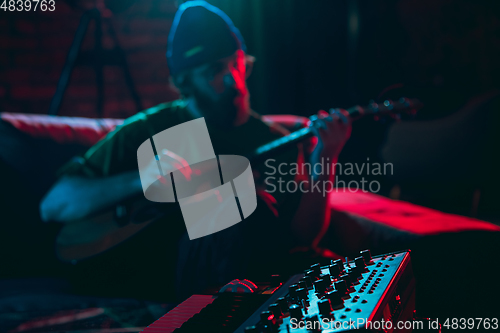 Image of Close-up of musician performing in neon light. Concept of advertising, hobby, music, festival, entertainment.