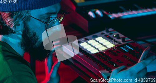 Image of Close-up of musician performing in neon light. Concept of advertising, hobby, music, festival, entertainment.