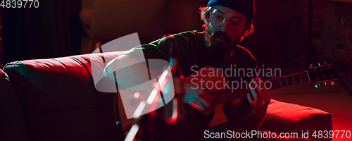 Image of Close-up of musician performing in neon light. Concept of advertising, hobby, music, festival, entertainment.