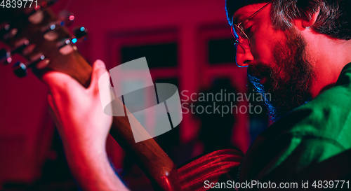 Image of Close-up of musician performing in neon light. Concept of advertising, hobby, music, festival, entertainment.